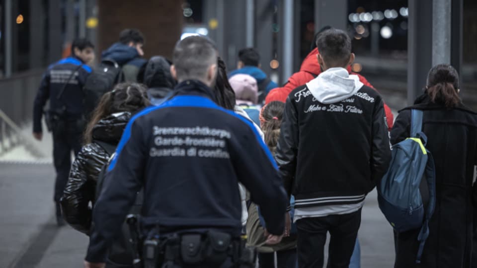 Grenzwächter nehmen an der Grenze zu Italien Asylsuchende in Empfang.