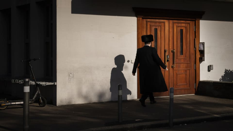 Ein Mann in jüdisch-orthodoxer Kleidung betritt die Synagoge Agudas Achim in Wiedikon in Zürich.