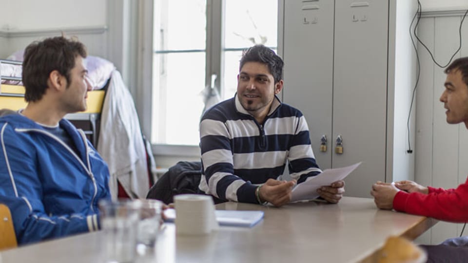 Drei Männer im Gespräch im Asylcenter Gutshof in Enggistein, Worb, Bern im Februar 2013.