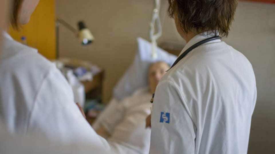 Eine Oberärztin besucht im Krankenhaus einen Patienten. Symbolbild.