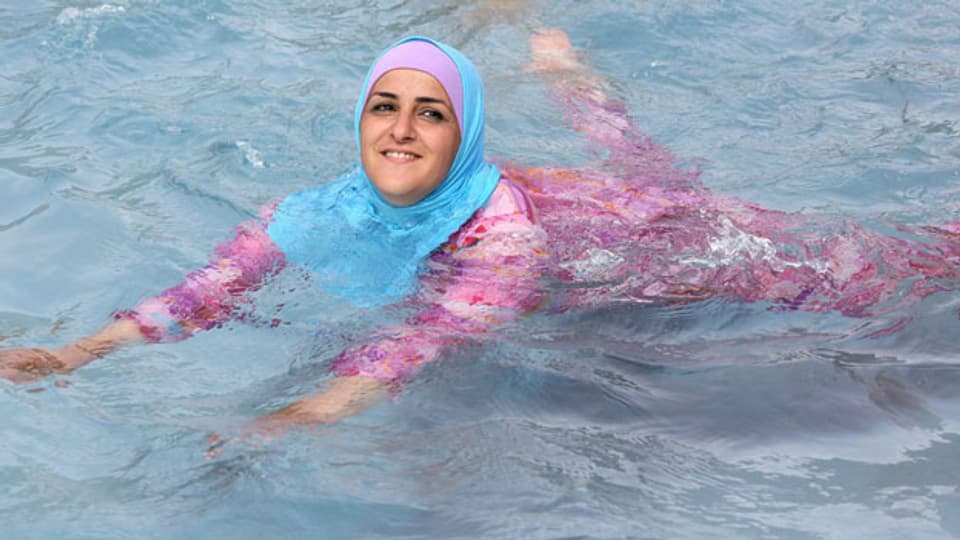 Türkisches Mädchen beim Schwimmen im Burkini. Symbolbild.