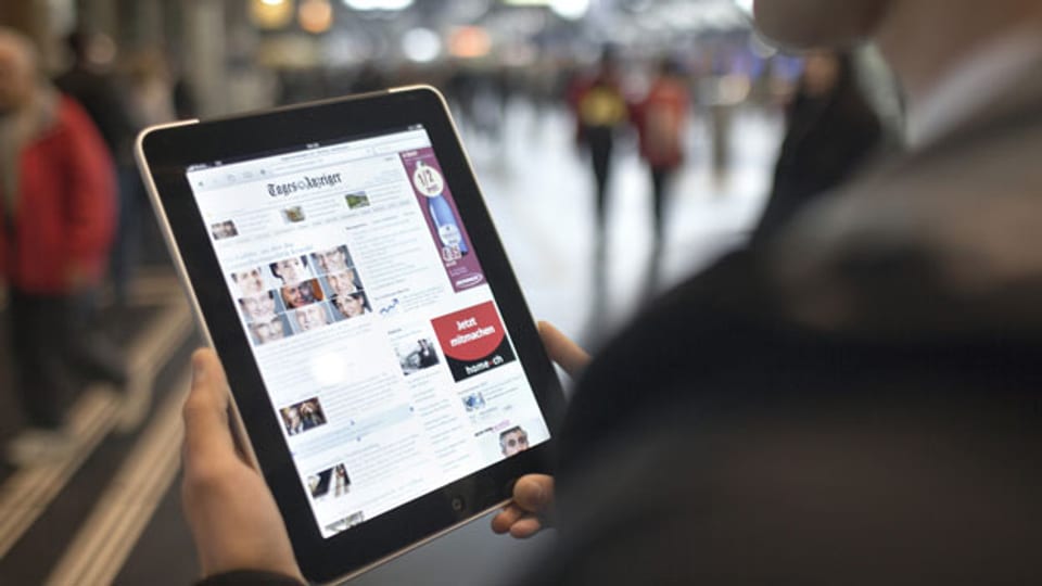 Ein Mann liest am auf einem iPad am Hauptbahnhof in Zürich die Online-Ausgabe des «Tages Anzeigers». Symbolbild.