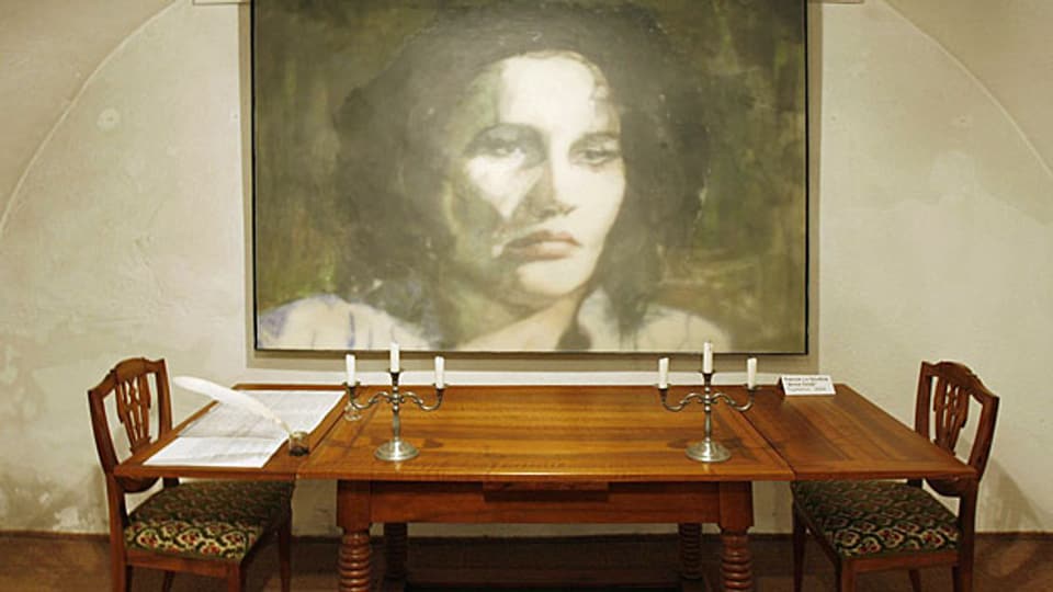 Ein Richtertisch und ein - nicht authentisches - Portrait von Anna Göldi im Anna Göldi-Museum in Mollis.