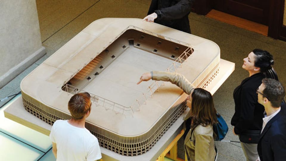 Personen schauen sich das Modell «Hypodrom» des neuen Zürcher Stadions an, am Donnerstag, 4. Juli 2013, anlässlich einer Ausstellungseröffnung in Zürich. Nach heutigem Stand der Projektierung werden die anvisierten Zielkosten von 150 Millionen Franken eingehalten.