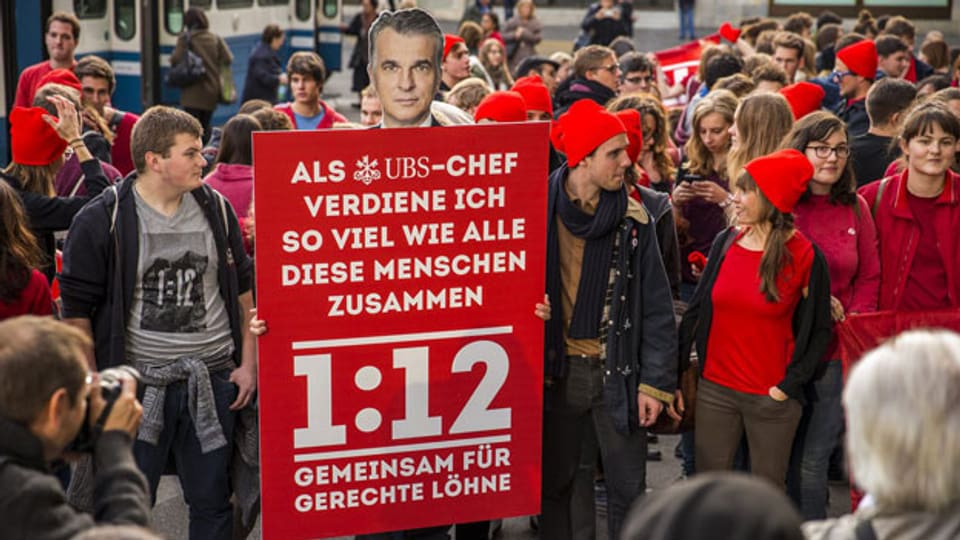 Mitglieder des Initiativ-Komitee 1:12 und der JUSO demonstrieren mit einem Plakat und einem Foto des UBS CEO Sergio Ermotti auf dem Paradeplatz, am 2. November 2013 in Zürich.