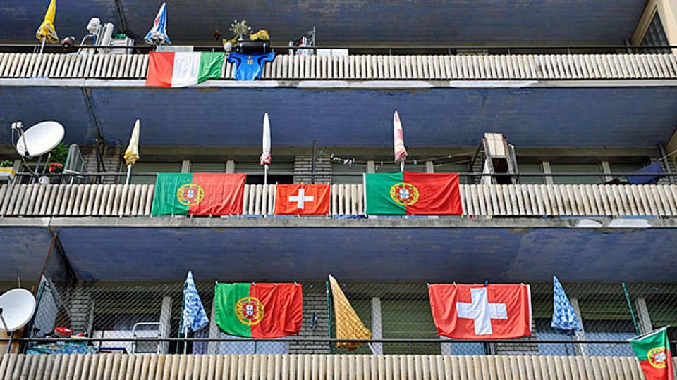Portugiesische und schweizerische Fahnen an einem Haus in Neuenburg.