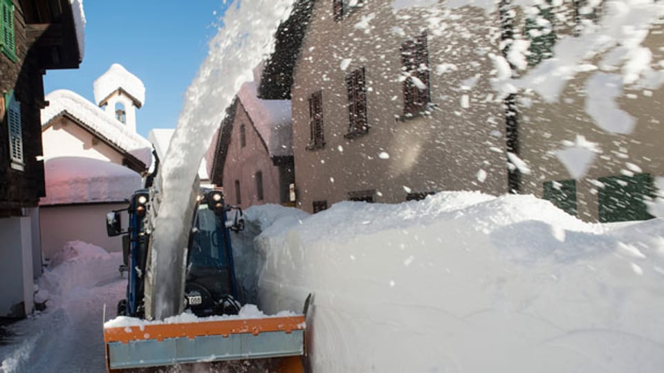 Das Dorf Bedretto wird am Freitag, 27. Dezember 2013, vom vielen Schnee befreit. Mittlerweile türmt sich der Schnee über zwei Meter hoch.