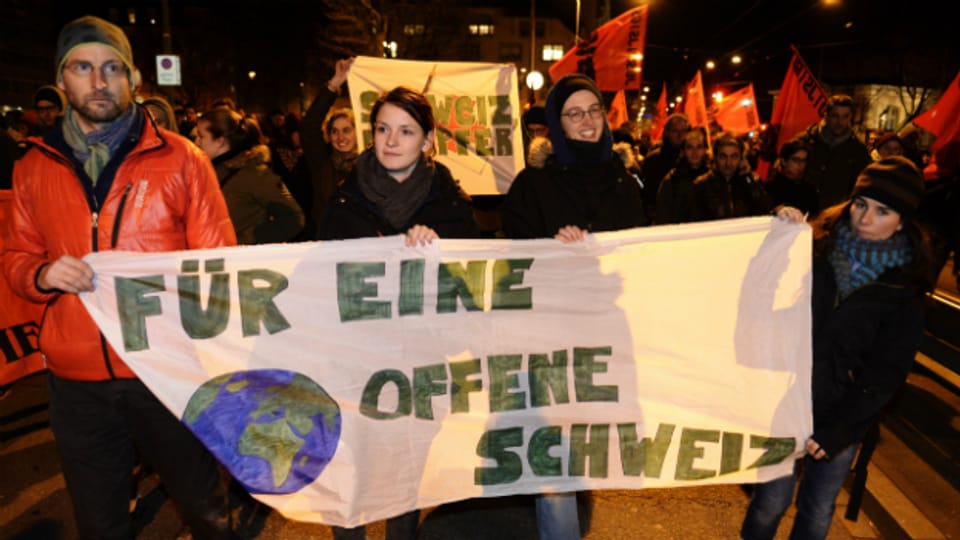 Demonstranten halten ein Transparent "für eine offene Schweiz" in den Händen.