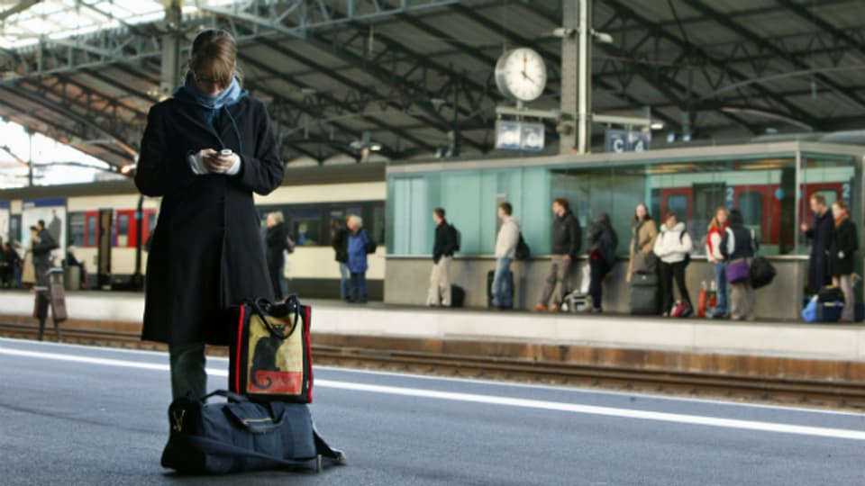 Begehrte User: Eine Pendlerin surft mit ihrem Handy am Bahnhof Lausanne.