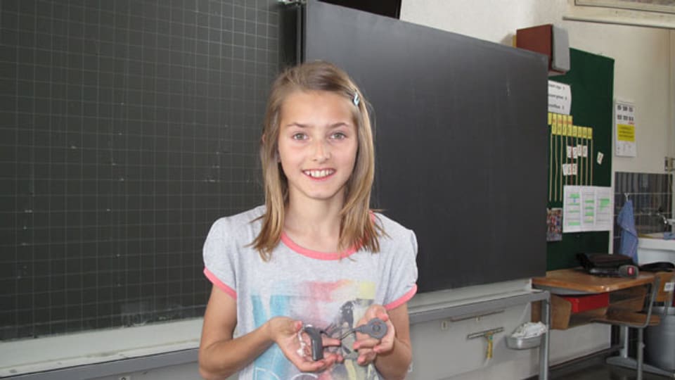 Die 12jährige hörbehinderte Sonja zeigt ihr Hörgerät.