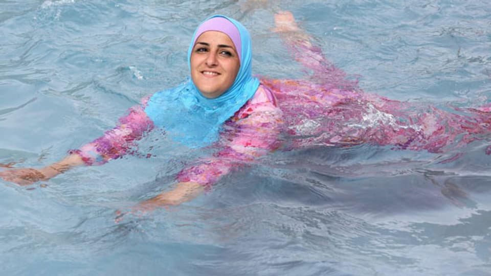 Eine junge türkische Frau beim Schwimmen im Burkini. Symbolbild.