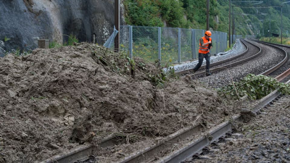 Ein Geologe überprüft den Erdrutsch auf den Gleisen der SBB-Strecke Bern - Lausanne am Sonntag, 13. Juli 2014 bei Flamatt.