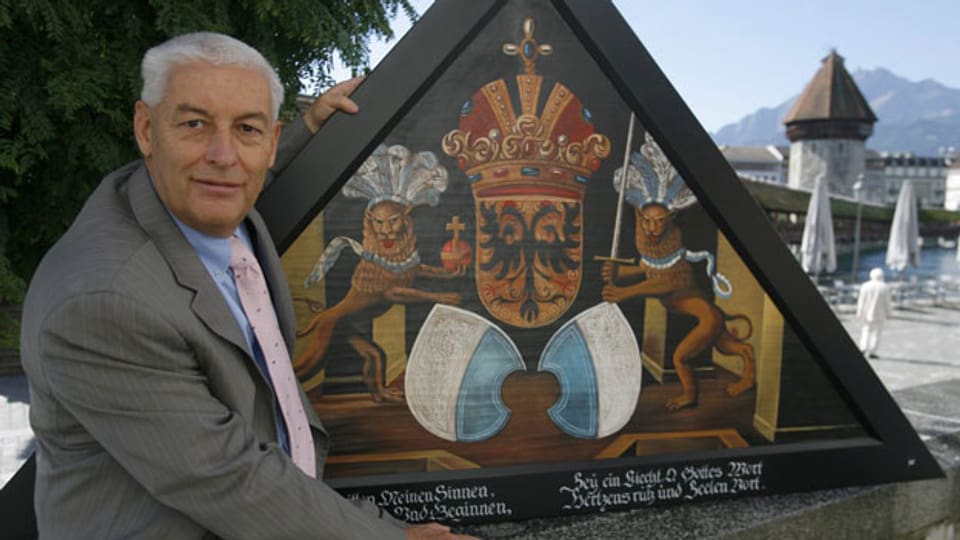 Jost Schumacher mit einem neu gemalten Bild vor der Kapellbrücke in Luzern. Der Kunstliebhaber investierte rund 2 Millionen Franken, um die 146 verbrannten Bilder historisch aufzuarbeiten und neu zu malen.