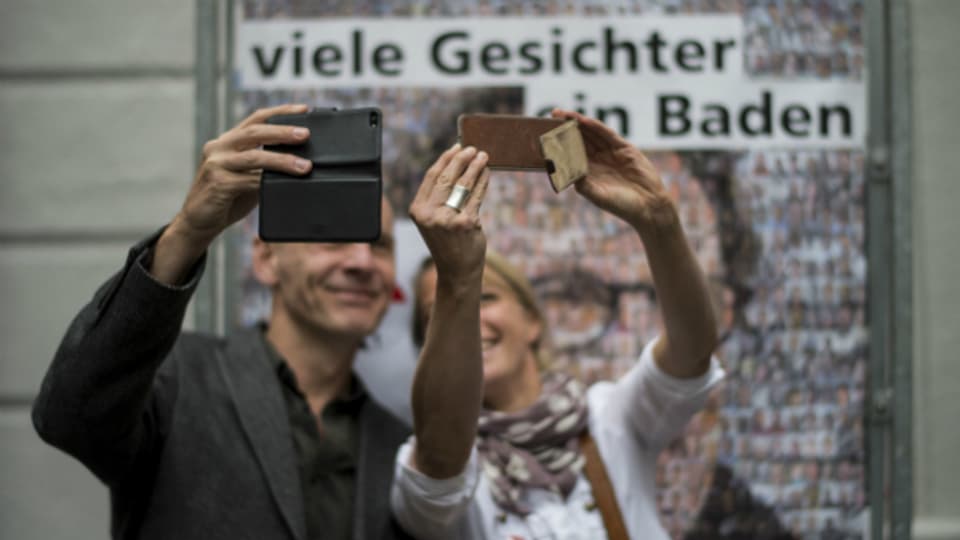 Menschen machen ein Selfie vor einem Portrait von Geri Müller am 25. August in Baden.