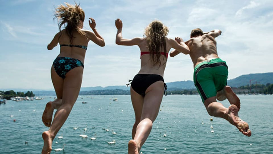 Junge Menschen kühlen sich mit einem Sprung in den Zürichsee ab. Symbolbild.