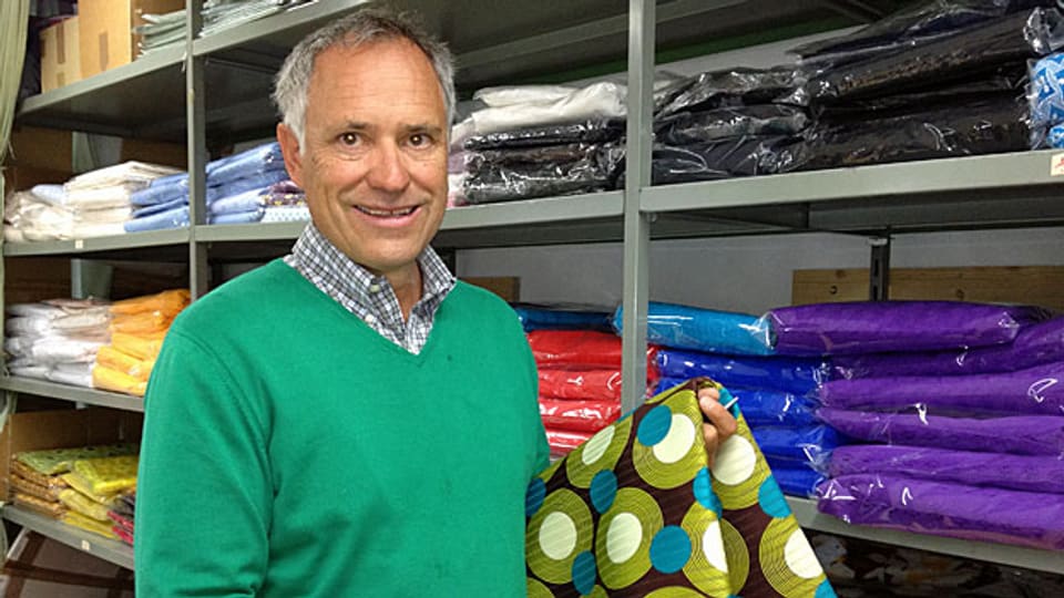 Matthias Hée , Geschäftsleiter und Inhaber des Textilunternehmens Okutex, vor bunten Stoffbahnen, eingepackt in transparente Folien, in seiner Spedition in St. Gallen.
