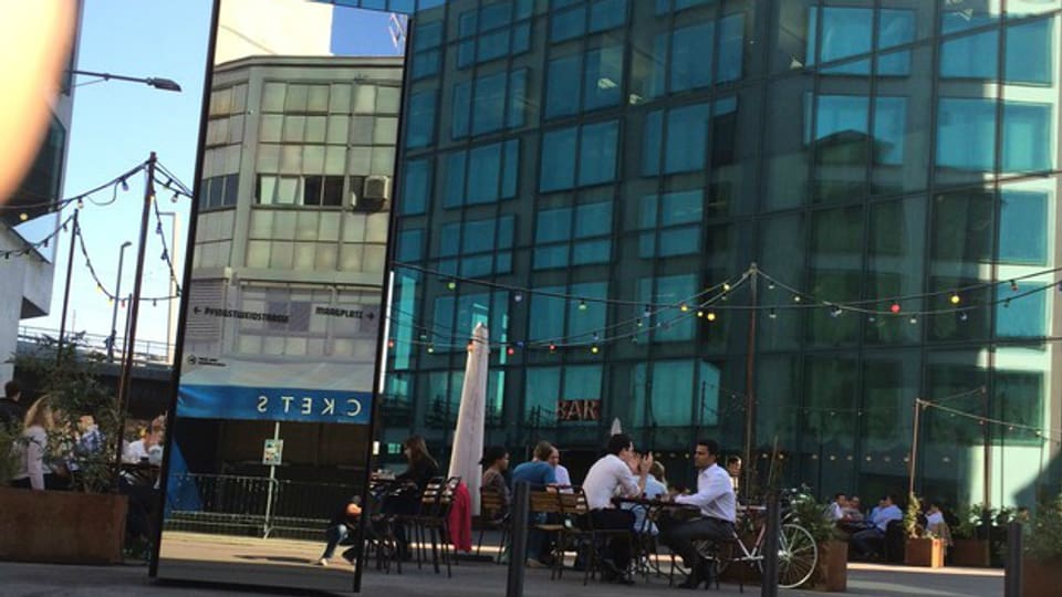 Vergangenheit und Zukunft nahe beieinander: Café am Fusse des Prime-Towers, im Spiegelbild die alte Maag-Halle. SRF