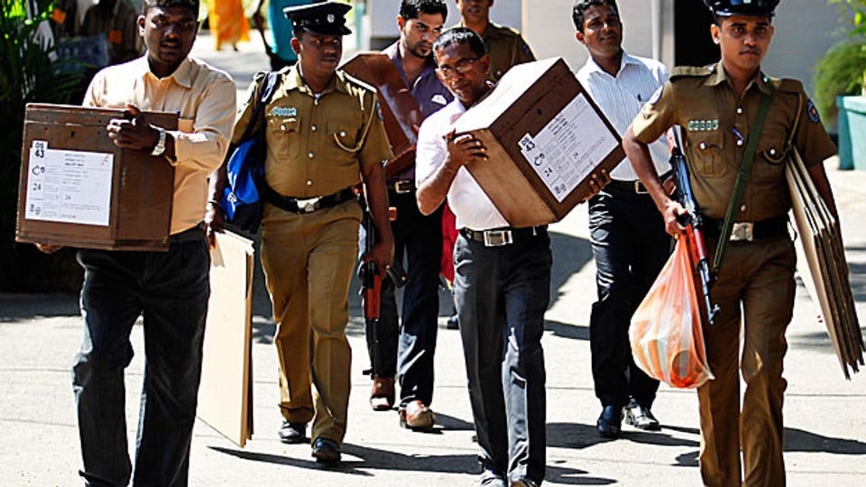 Helfer bringen in Colombo Wahurnen in die Wahllokale.