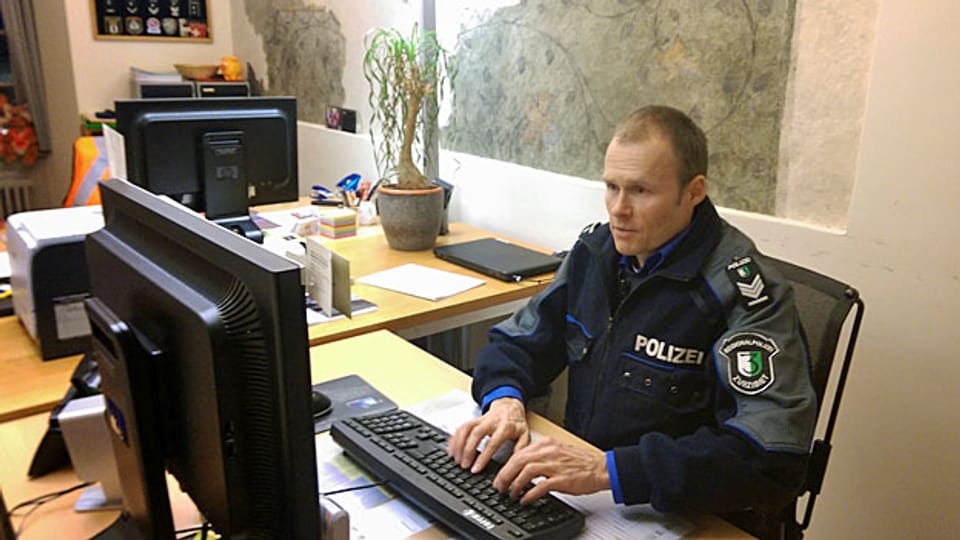 Roger Schneider von der Regionalpolizei Zurzibiet an seinem Arbeitsplatz vor dem Computer.