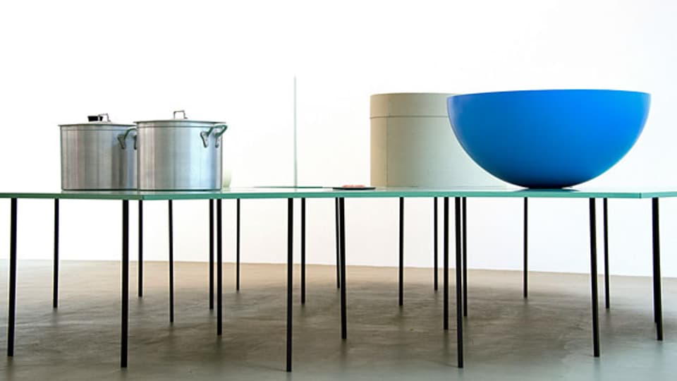Das Kunstwerk «Acht Tische mit acht Gegenständen» der deutschen Künstlerin Katharina Fritsch das in der Ausstellung «One Million Years - System und Symptom» im Museum für Gegenwartskunst in Basel von 2014 bis 2015 zu sehen war.
