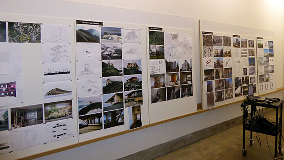 Eine Wand mit Bildern laufender Projekte, im Basler Büro von Herzog & de Meuron.