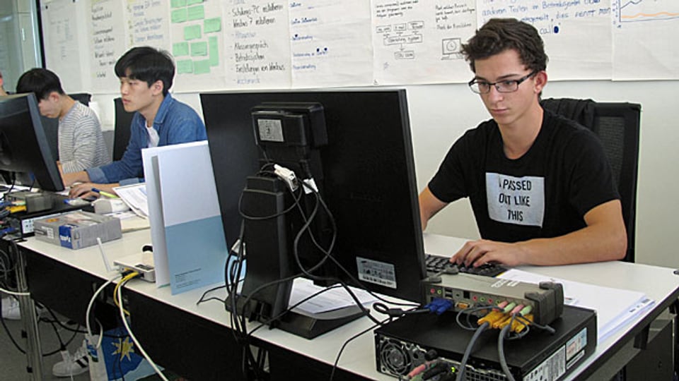 Konzentriert schaut Yannick Burkhart (rechts) auf den Bildschirm, öffnet da ein Fenster, klickt dort auf ein Kästchen. Seine Aufgabe: er soll einem Klassenkollegen einen Fehler im System einbauen.