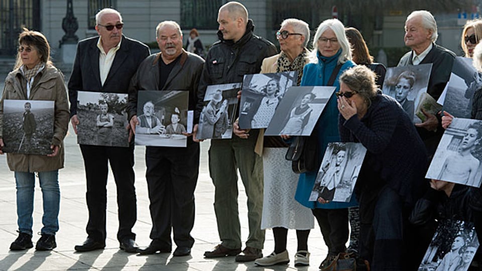Ehemalige Verdingkinder und Opfer fürsorgerischer Zwangsmassnahmen posieren mit Kinderfotos vor dem Bundeshaus. Bild vom 31.3.2014.