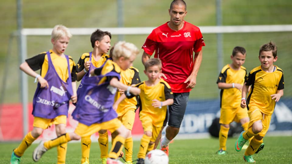 Der Schweizer Fussball-Nationalspieler Gökhan Inler (Mitte) spielt am Kindertraining mit Kindern.