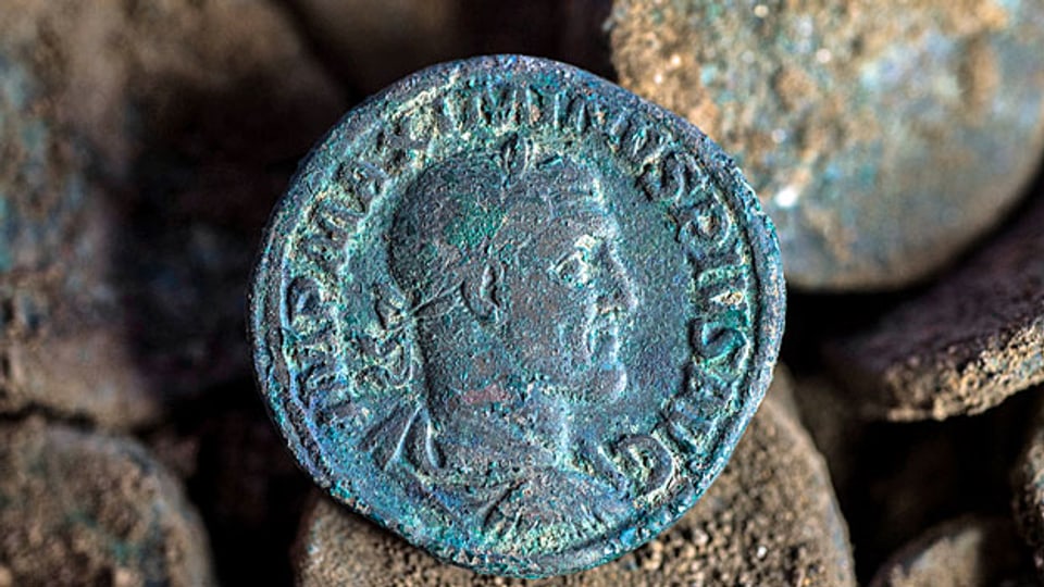 Eigentlich war es ein Maulwurf, der den Schatz ausgebuddelt hat. Der Landwirt entdeckte die grün schimmernden Münzen nämlich auf einem Maulwurfshügel. Bild: Römische Münze aus dem 3. Jahrhundert, gefunden 2014 im Tessin.