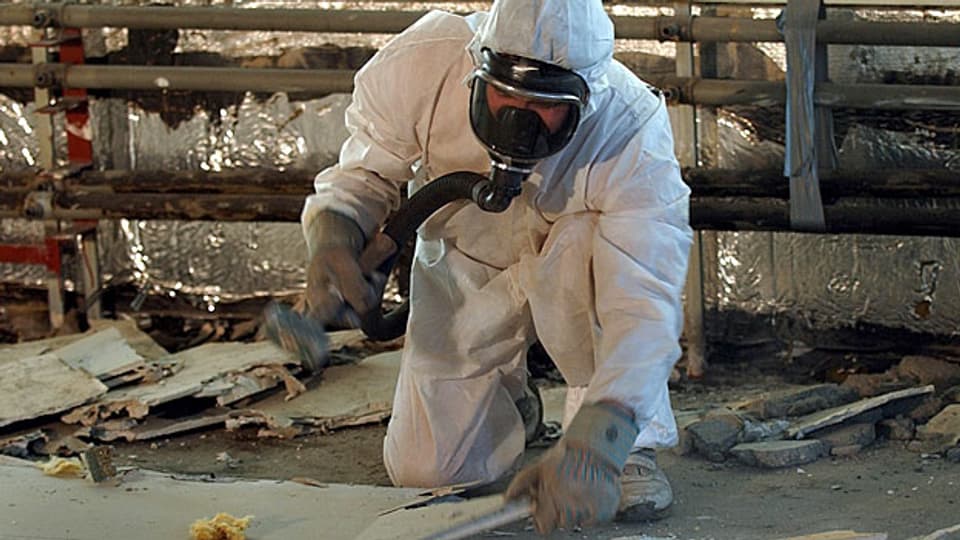 Für Asbestopfer, die schon heute von ihrer Krankheit wissen, soll es eine Ausnahme geben. Allerdings auch nur dann, wenn für sie kein Fonds zustande kommt, aus dem sie finanziell entschädigt werden können. Bild: Arbeiter bei einer Asbestsanierung im Februar 2003.