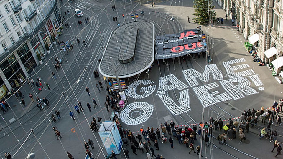 «Game Over» ist auf dem Boden des Zürcher Paradeplatzes zu lesen - am Aktionstag der Initianten. Banken, Versicherungen und Rohstoffhändler sind damit nicht einverstanden.