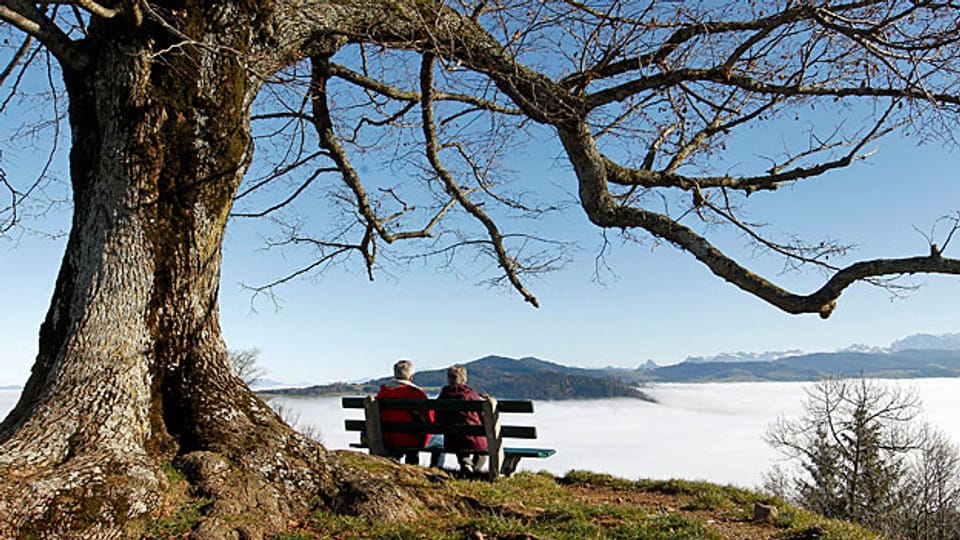 Das ältere Paar geniesst die Aussicht auf die Alpen über dem Nebel. Jüngere haben allen Anlass, sich um ihre Aussichten auf eine sichere Pension Sorgen zu machen.