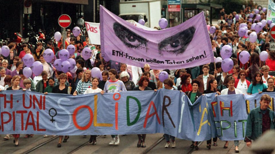 Streikende Frauen auf der Strasse vor dem Unispital in Zürich anlässlich des nationalen Frauenstreiks vom 14. Juni 1991. Die Frauen forderten die Umsetzung des 1981 in Kraft getretenen Verfassungsartikels über die Gleichstellung von Mann und Frau.