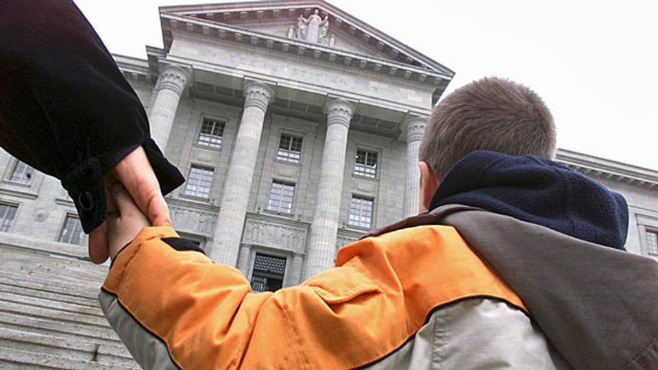 Ein Kind an der Hand seines Vaters vor dem Bundesgericht.