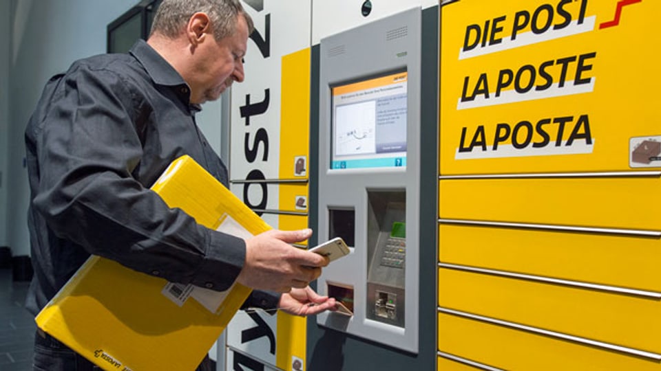 Ein Mitarbeiter der Post bedient einen «My Post Automaten» des Post-Netzes der Zukunft.