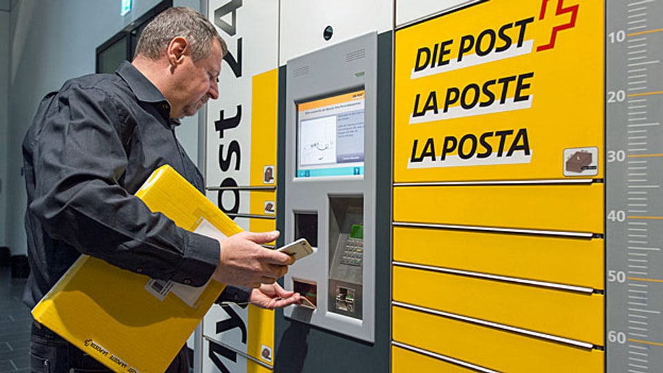 Ein Post-Mitarbeiter bedient einen «My Post Automaten». Längst nicht allen Postkunden gefällt der Service-Abbau der Post.