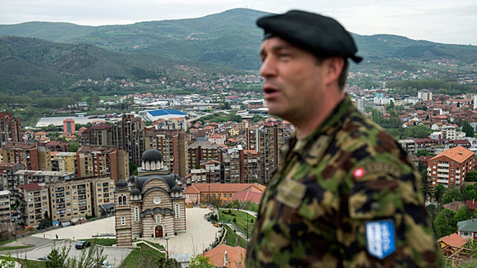 Ein Swisscoy-Soldat steht auf einer Anhöhe über der Stadt Mitrovica.