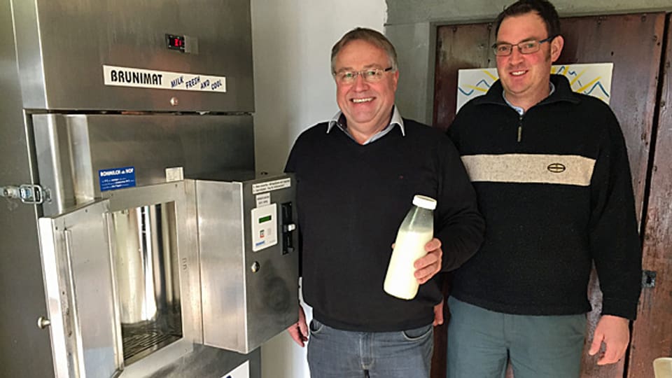Der Erfinder des Milchautomaten, Alfred Bruni, und der Milchbauer Christian Zeller stehen neben dem «Brunimat».