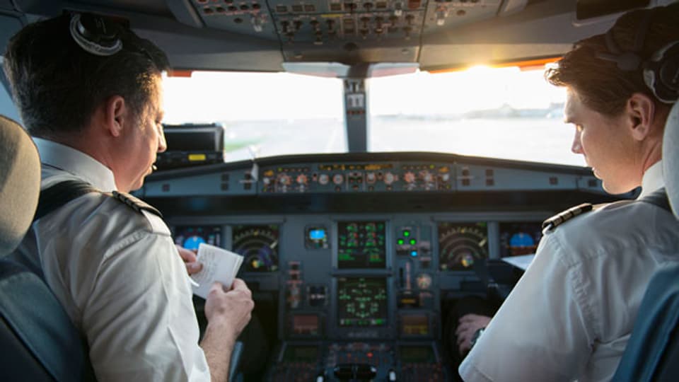 Die Piloten bereiten sich im Cockpit auf den Flug vor.
