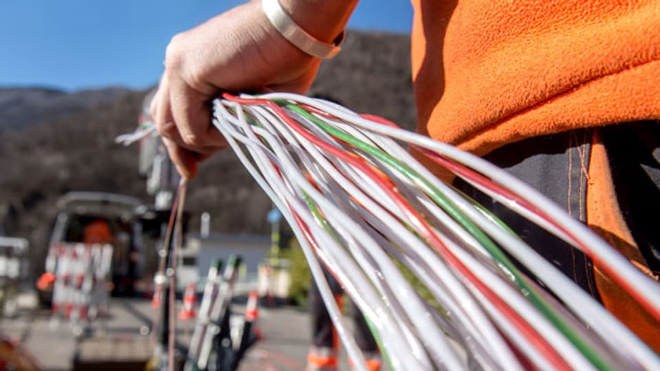 Ein Arbeiter montiert Glasfaserkabel der Swisscom für den Internetanschluss in Bellinzona.