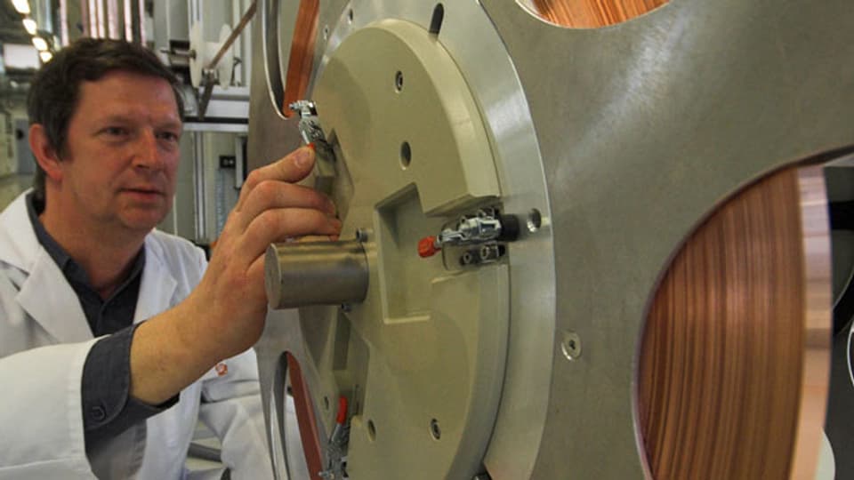 Symbolbild. Ein Ingenieur befestigt eine Spule mit Kupferband in einer Produktionsanlage.