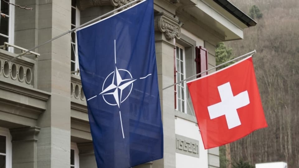 Die Schweizer Fahne hängt neben einer Nato-Flagge.