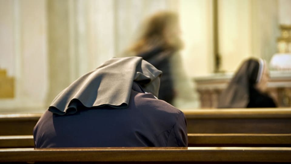 Betende Nonne in einer Kirche. Symbolbild.