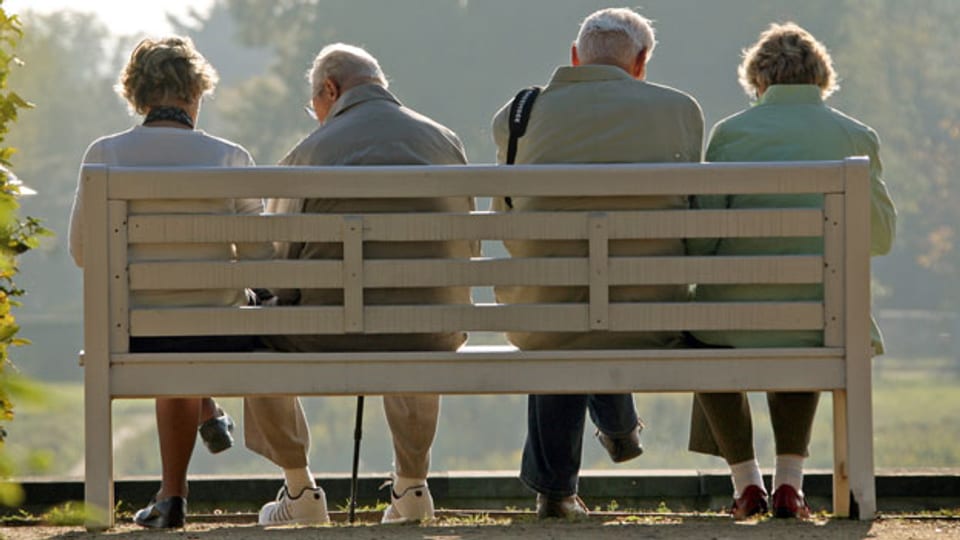 Rentner sitzen auf einer Bank im Park.