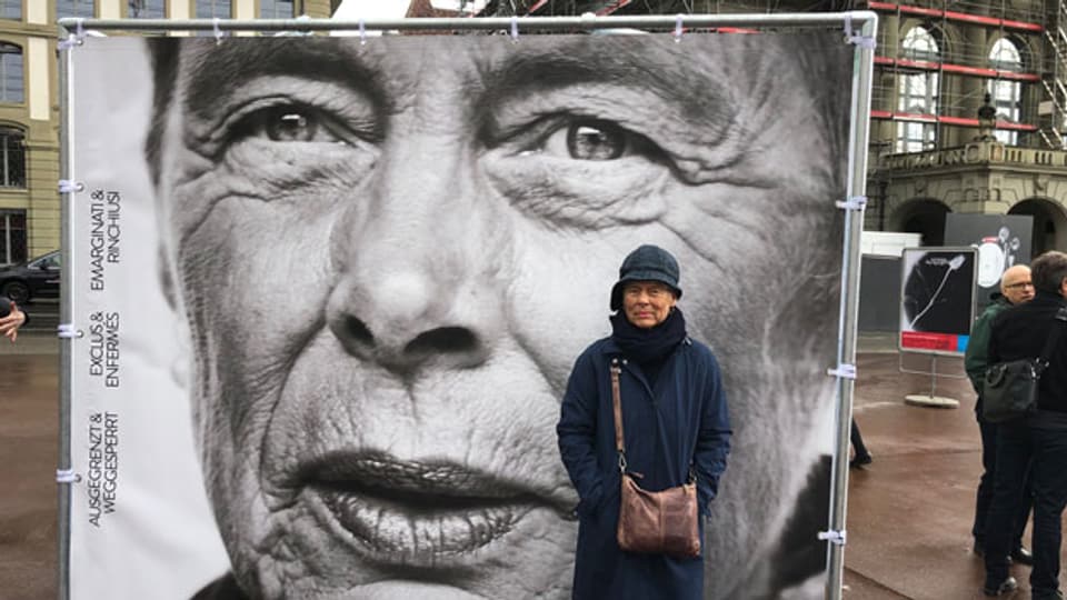 Mili Kusano, eine der sogenannt administrativ Versorgten, vor ihrem eigenen Konterfei in Bern.