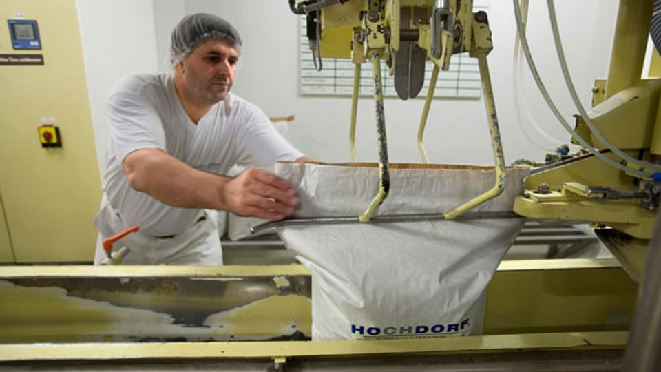 Ein Arbeiter füllt in der Fabrik der Firma Hochdorf Milchpulver in einen Sack.