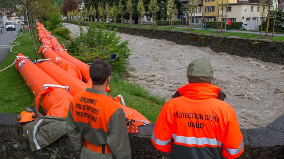 Zivilschützer bauen Hochwasserschutzdämme bei Hochwassergefahr.