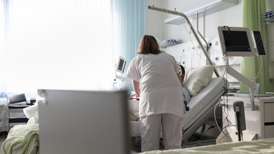 Eine Krankenschwester betreut einen Patienten im Inselspital Bern.