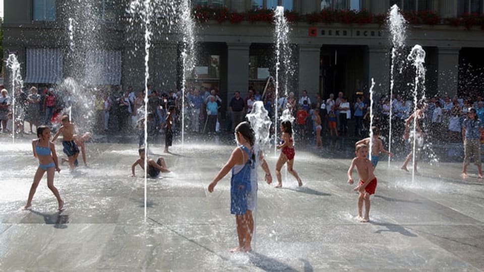 Die grösste Freilicht-Dusche der Schweiz. Kinder spielen im Wasserspiel auf dem Bundesplatz.