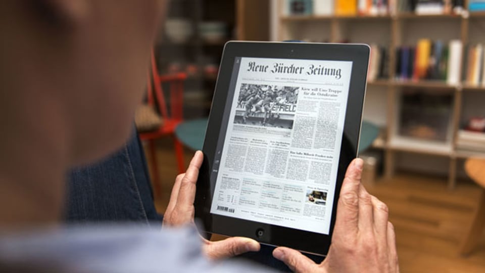 Ein Leser liest die NZZ online an einem iPad.